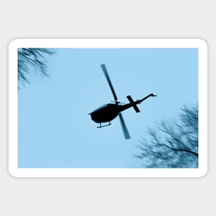 A Bell UH-1 Huey Iroquois flying low over trees Sticker